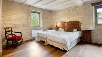 Une chambre à coucher avec un lit en bois, une chaise, une table de chevet et une fenêtre.