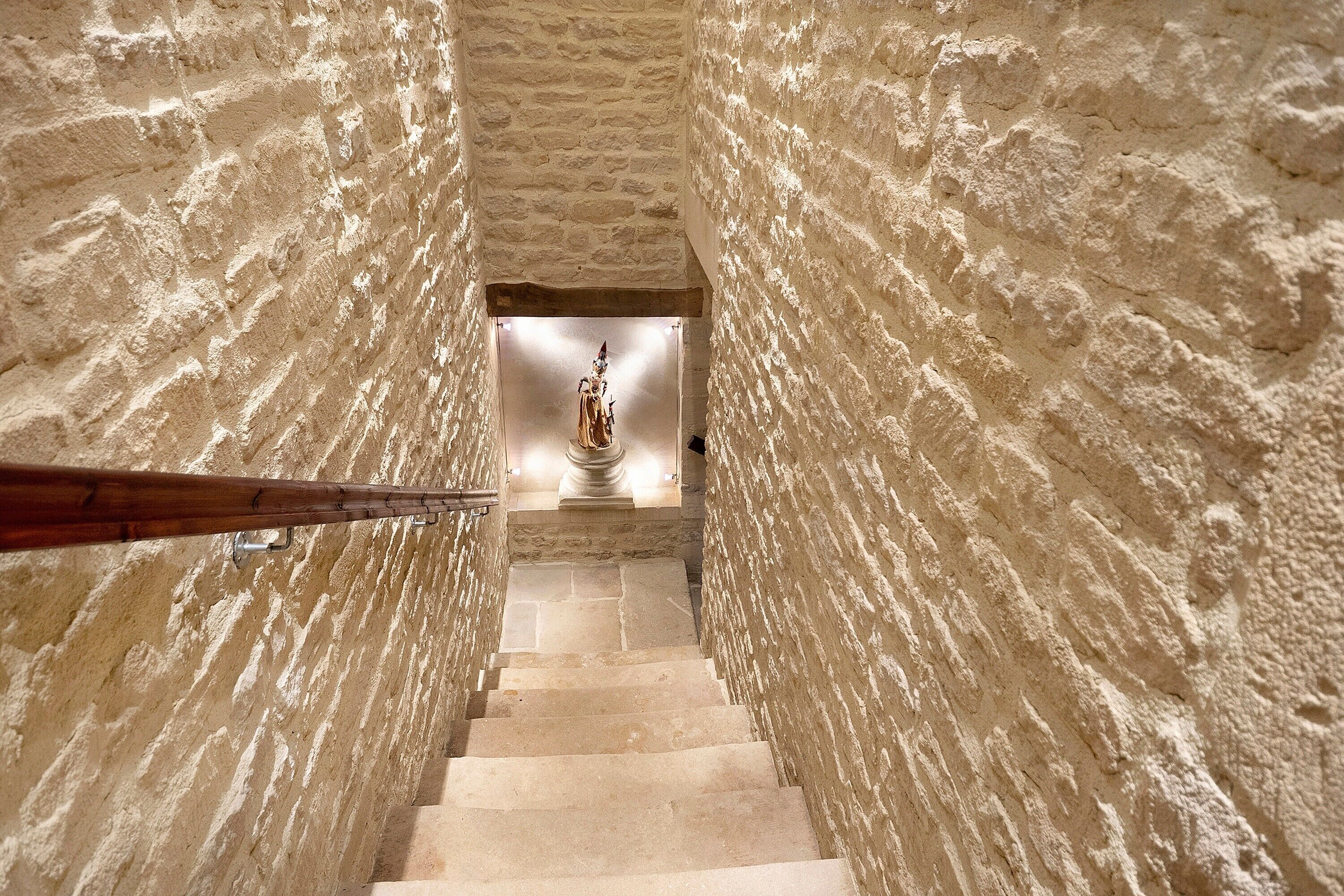 Eine Treppe mit Steinwänden, die zu einer Statue führt.