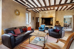 Ein Wohnzimmer mit Kamin, Ledersofas und einem Couchtisch.