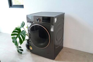 Eine kompakte, graue Waschmaschine mit Frontlader, digitaler Anzeige, Bedienfeld und einer 2C-Kennzeichnung.