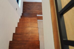 Eine Holztreppe mit Handlauf und Türrahmen oben.