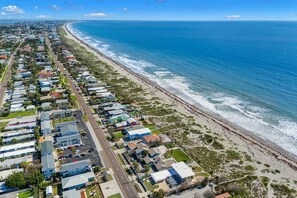 A coastal residential area with houses along the beachfront, a clear sky, and a calm sea. - 755 S Atlantic Ave (Cocoa Beach)
