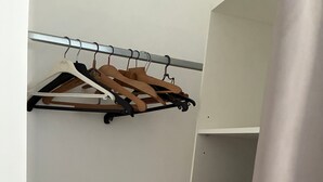 A bunk bed with a hanging rack above it, a bedside table with a pillow, and a curtain partially drawn. - Air-conditioned “La Grange” House with Private Terrace, Wi-Fi, and AC (Azay-le-Rideau)