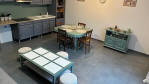 Eine kompakte Küche mit Essbereich, einem Backofen und einer Kaffeemaschine.