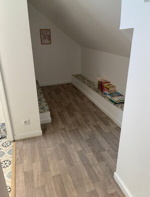 A narrow hallway with a built-in bench and a stack of books on the right.