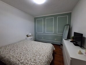 A bedroom with a bed, a dresser, a mirror, and a television. - A spacious and cozy home just a few minutes from Porto (Porto)
