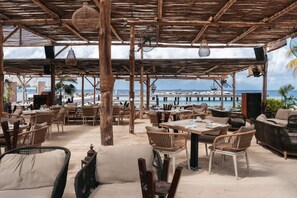An outdoor seating area with wicker furniture and a view of the beach and ocean. - LUX 2BD/2Bath Condo - ONE Mambo Beach 1 by Bocobay (Willemstad)
