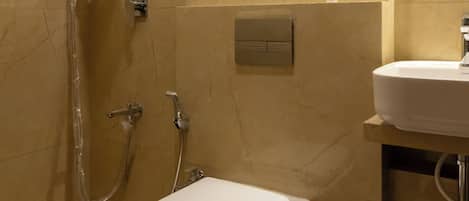 A bathroom with a toilet, shower, and sink.