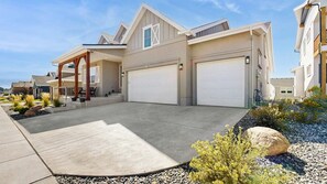 A residential property with a garage, a covered patio, and a landscaped driveway.