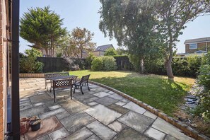 A patio with stone flooring, a table, and two chairs. - Host Stay Sandmoor (Whitby)