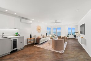 A spacious living area with a kitchen, a dining area, and a seating space with a view. - Oceanfront AC Fully Remodeled Unit (Solana Beach)