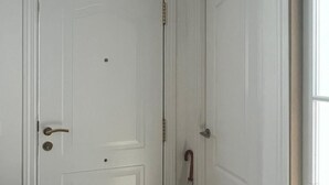 A white door with a handle, a small trash bin, and a white air conditioning unit mounted on the wall. - The Magical Village - 5 minutes from the beach (Calonge)