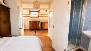 Un dormitorio con cama, cómoda de madera y vestidor.