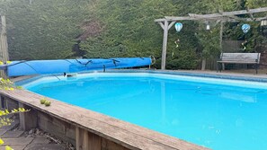Una piscina con cubierta de madera y zona techada.