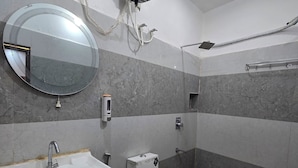 Et badeværelse med vask, toilet og spejl.