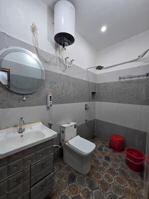 A bathroom with a sink, mirror, toilet, and shower. - VIP Inn (Ayodhya)