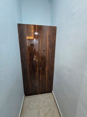 A room with a large wooden wardrobe and a tiled floor. - VIP Inn (Ayodhya)