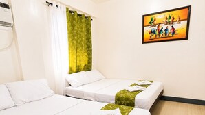 Una habitación de hotel con dos camas, un cuadro en la pared y una ventana con cortinas.