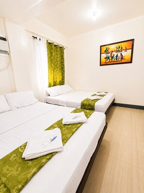 A hotel room with two beds, a painting on the wall, and a window with curtains. - Metrohive Apartment 3C - Cozy Studio Near Airport & PITX (Pasay City)