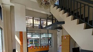 Un amplio vestíbulo con mesa de billar, escalera y candelabro.
