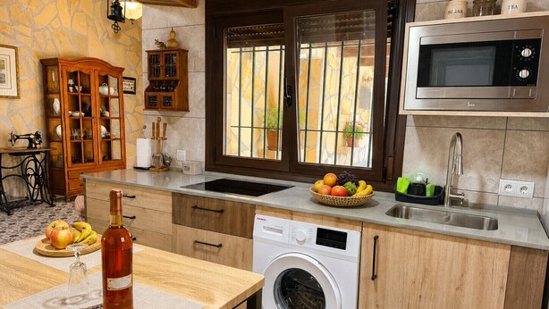 Cocina compacta con lavadora, microondas y lavaplatos.