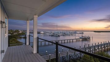 A wooden deck with a view of a marina and boats.