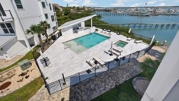 A rooftop pool with a view of a marina and a white building. - Three-Story Home | Boat Slip | Walk Downtown (Saint Augustine)