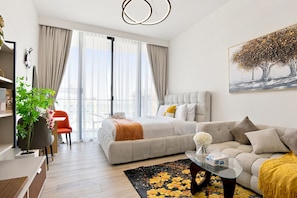 A modern hotel room with a bed, sofa, and a dining area. - Stunning View Apartment Luxurious Living Peaceful (Dubai)