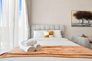 A hotel room with a bed, a painting, and a view of the outdoors. - Stunning View Apartment Luxurious Living Peaceful (Dubai)