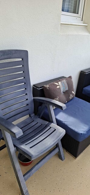 A blue outdoor seating area with a chair and a cushioned bench. - T2 RDC avec jardin - LACANAU OCÉAN (Lacanau)
