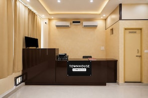 A reception desk with a sign reading 'TOWNHOUSE OYO-Serviced'.