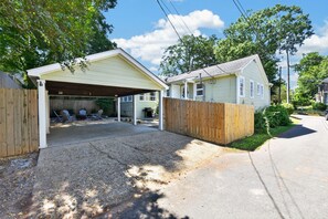 A residential property with a detached garage, a covered patio, and a fenced yard. - Capstone Cottage | Walk to Bryant-Denny Stadium | 3 King Beds (Tuscaloosa)
