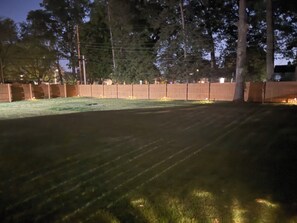 A nighttime view of a fenced yard with a well-maintained lawn. - Private Basement Retreat in South Bend 10 min from Notre Dame (South Bend)