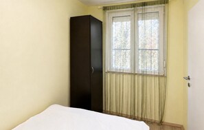 A bedroom with a single bed, a wardrobe, and a window with curtains. - Beautiful apartment in Kavran with WiFi (Kavran)
