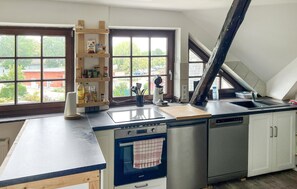 A kitchen with a built-in oven, a sink, and a window with a view of the outside. - 3 bedroom amazing apartment in Kalkhorst (Kalkhorst)
