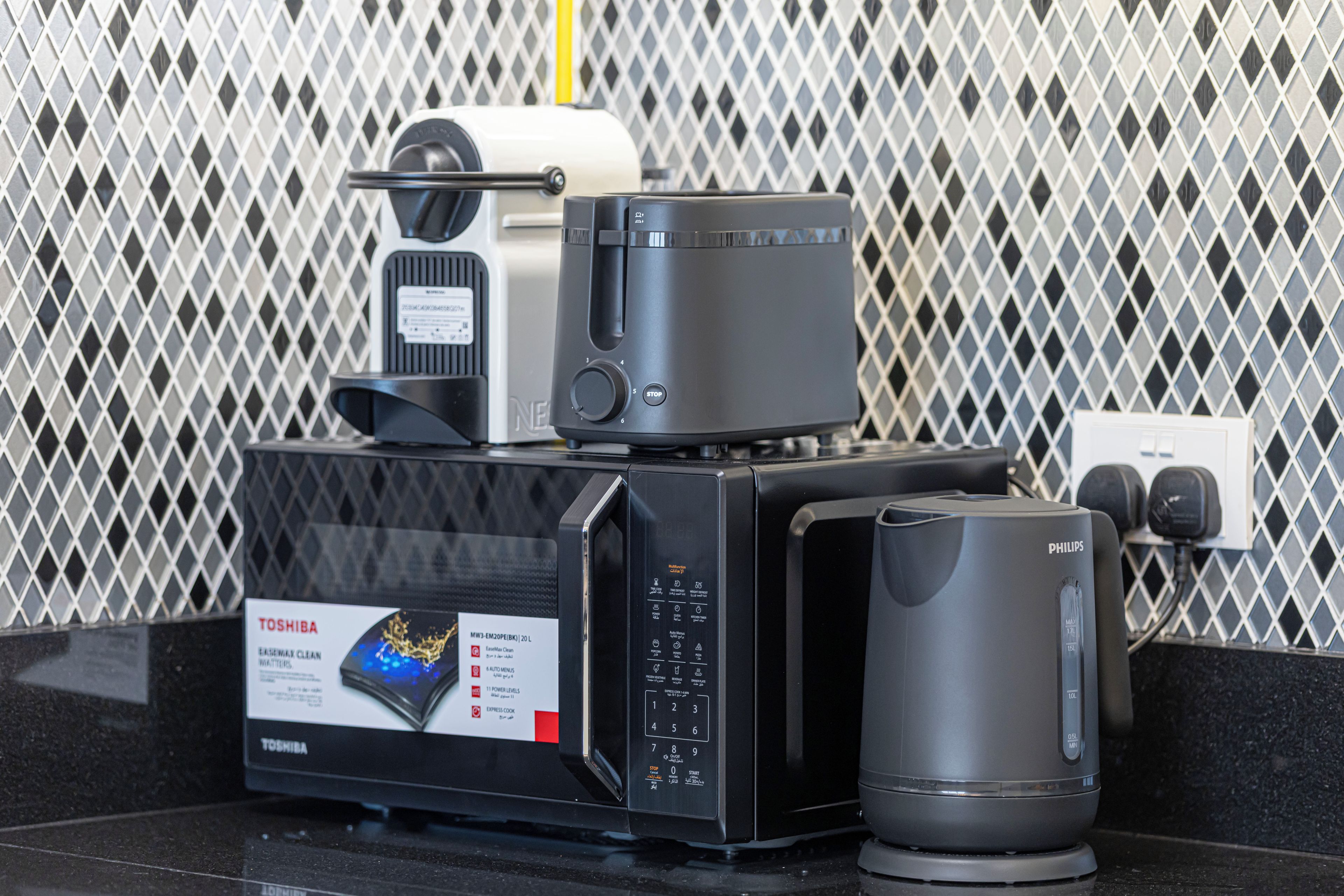 A kitchen with a microwave, toaster, and coffee maker on the countertop.