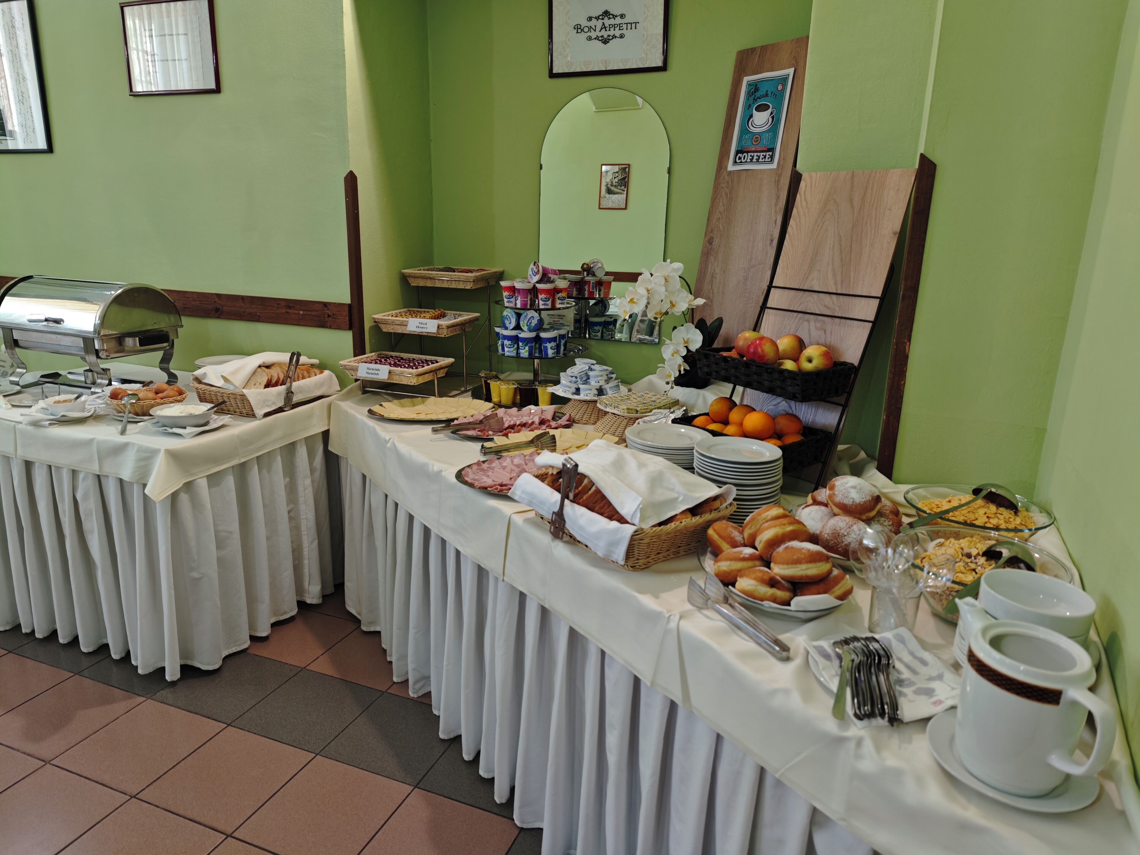A buffet setup with various food items and a coffee station.