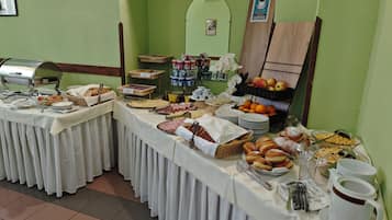 Montaje de bufé con diferentes opciones de comida y una estación de café.