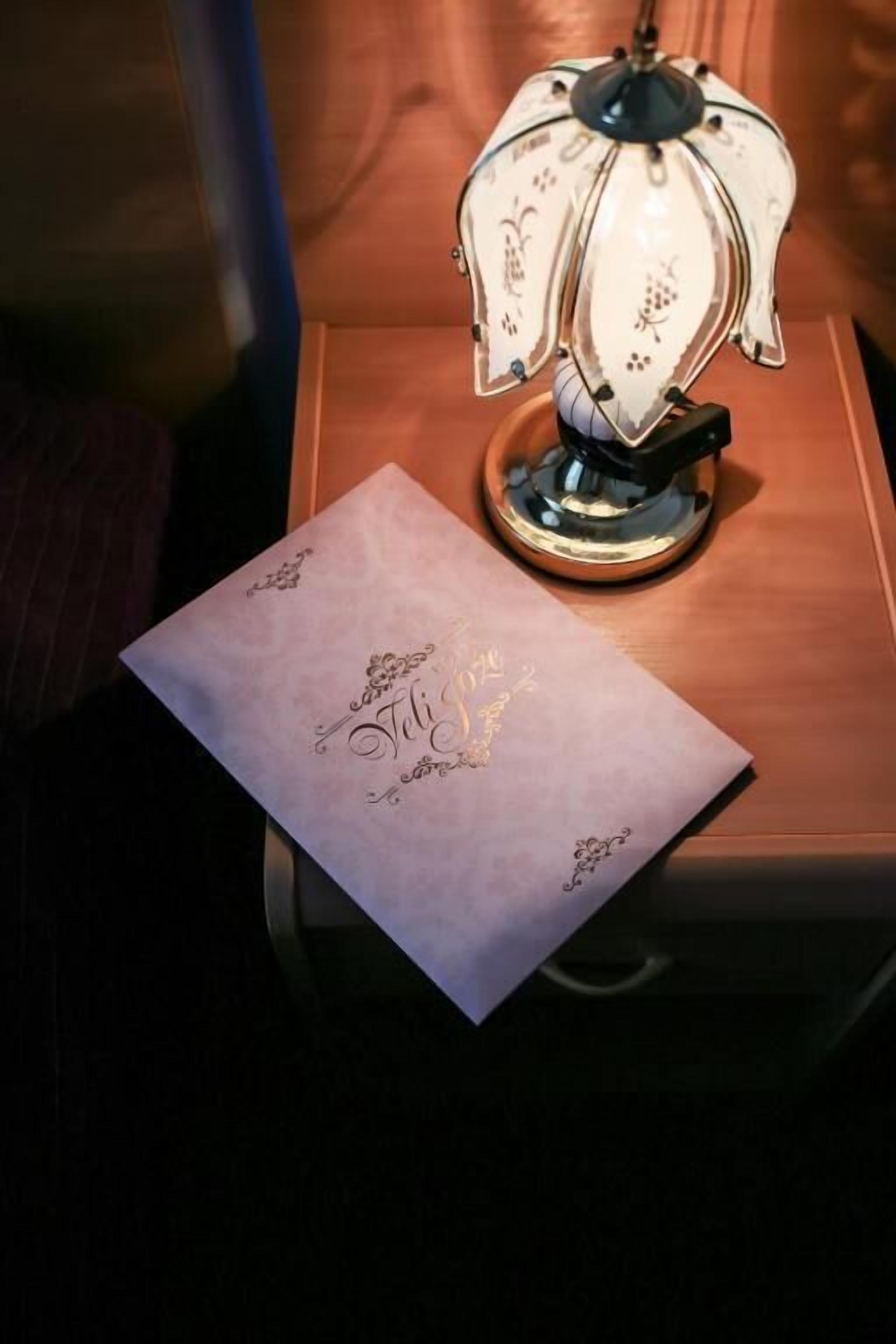 Uma lâmpada sobre uma superfície de madeira com um pedaço de papel com texto.