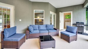 A covered patio area with wicker furniture and a grill. - Heated Pool & Lanai Cookouts! Cape Coral Getaway (Cape Coral)