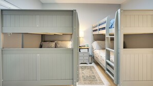 A room with bunk beds, a bedside table, and a lamp. - Heated Pool & Lanai Cookouts! Cape Coral Getaway (Cape Coral)