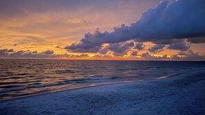 Ein Strand bei Sonnenuntergang mit Wellen im Meer.