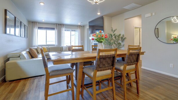 A dining area with a wooden table and chairs, a chandelier, and a view of the living room. - Private Yard w/ Patio! Modern Commerce City Gem (Commerce City)