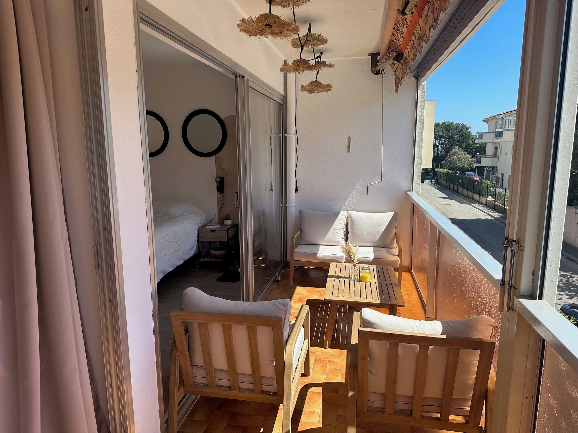 A balcony with a wooden table, two chairs, and a sofa.