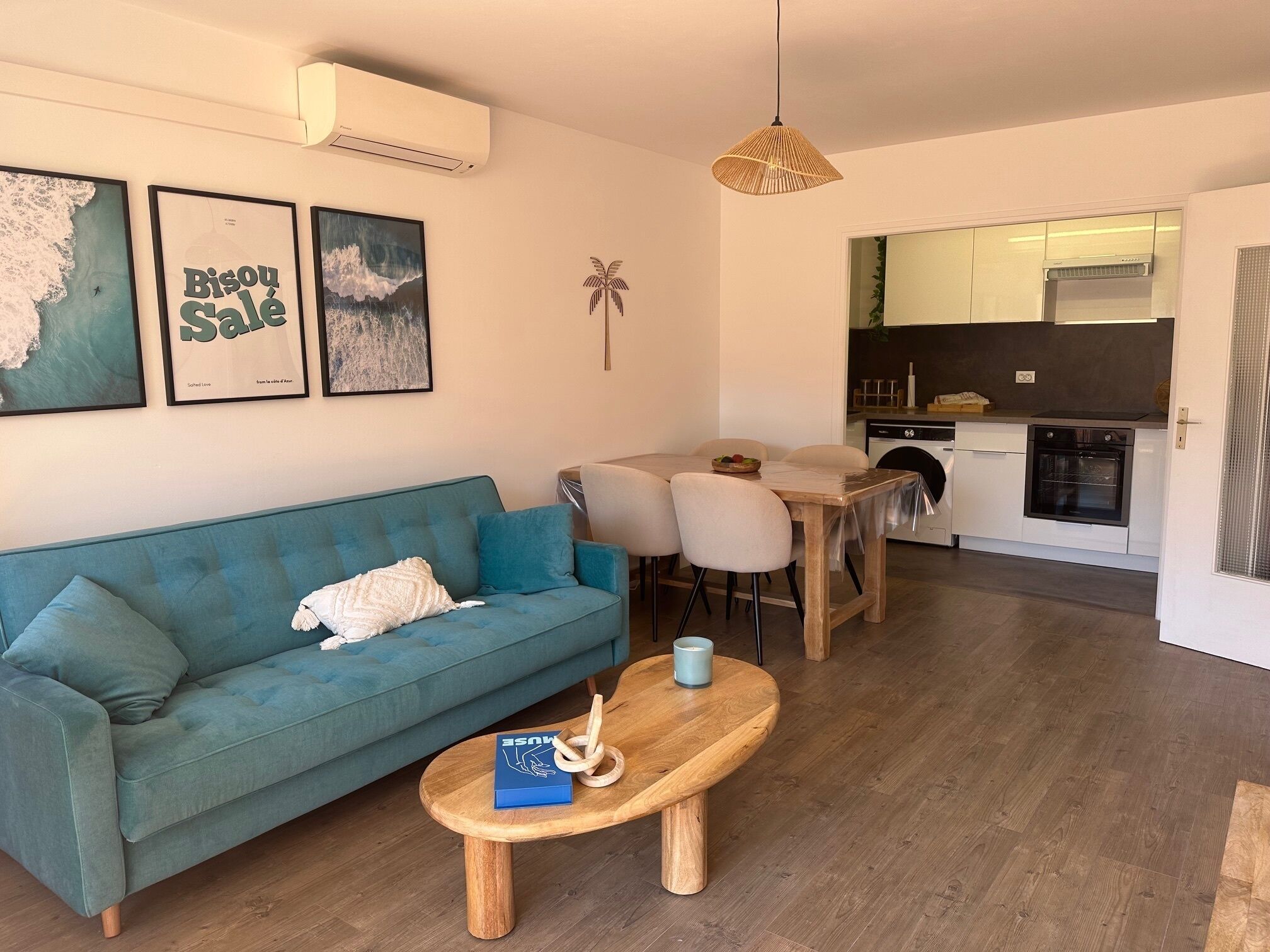 Un salon moderne avec un canapé bleu, une table basse en bois et un coin repas avec des chaises.