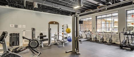 Un gimnasio con equipos de ejercicio variados, como cintas de correr, bicicletas estáticas y máquinas de pesas.