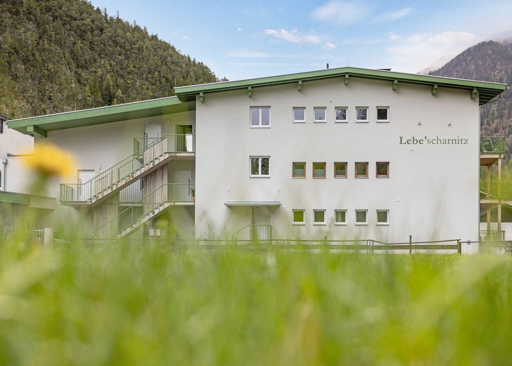 A two-story building with a green roof and multiple windows, labeled 'Lebe'schnitz.'