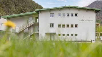 A two-story building with a green roof and multiple windows, labeled 'Lebe'schnitz.'