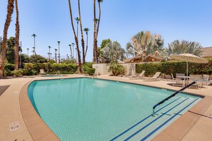 A clear swimming pool with lounge chairs and palm trees in the background. - Extended Getaway in the Heart of Palm Desert (Palm Desert)