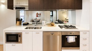 Uma cozinha moderna com eletrodomésticos embutidos, máquina de lavar louça e fogão.